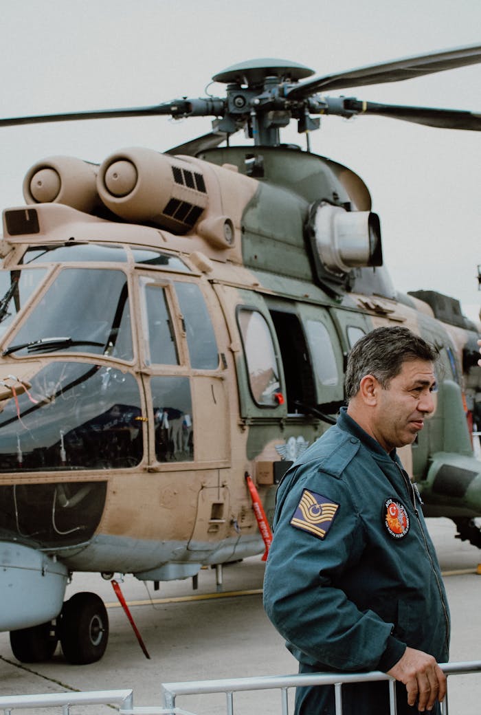 our-story A military pilot beside a helicopter in İstanbul, showcasing aviation and defense.