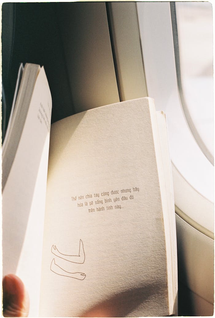 Enjoying peaceful literature during a flight by the airplane window.